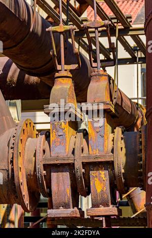 Engrenages et tuyaux corrodés et rouillés provenant de machines abandonnées Banque D'Images