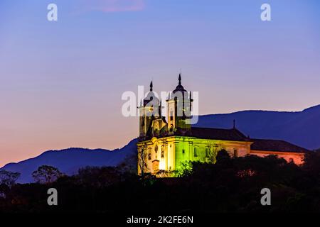 Vue nocturne de l'église historique du 18th siècle et des collines de la ville d'Ouro Preto Banque D'Images