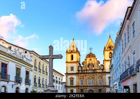 Vieilles maisons et églises de style colonial et baroque avec un crucifix sur la place centrale du Pelourinho Banque D'Images
