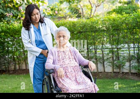 Aide médicale et soins asiatique senior ou âgée vieille femme patiente assise en fauteuil roulant dans le parc de l'hôpital de soins infirmiers, concept médical sain et fort. Banque D'Images