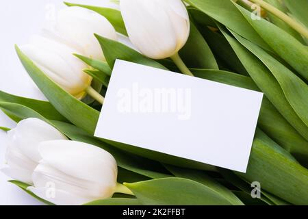 Maquette de carte de visite en papier blanc avec tulipes blanches. Concept commercial floristique. Banque D'Images