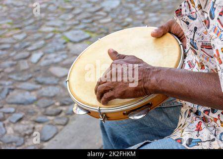 Exécution de Samba avec des mains de musicien jouant du tambourin dans les rues de la ville de Salvador Banque D'Images