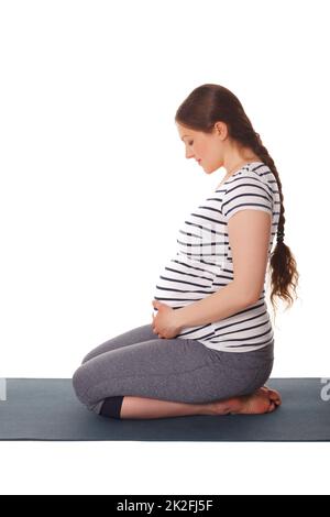 Femme enceinte faisant du yoga asana Virasana Banque D'Images