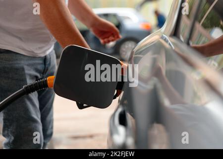 Main Man recharge et remplissage de fioul gaz à la station. Banque D'Images