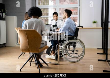 Homme d'affaires pour personnes handicapées assis au bureau avec ordinateur portable Banque D'Images