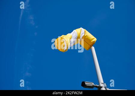 bonnette à vent jaune/tube textile sur un ciel bleu vif en journée, jour, vent Banque D'Images