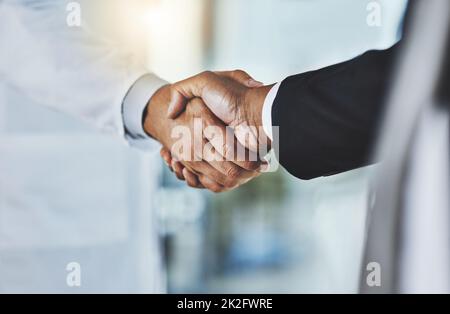 La clinique rencontre l'entreprise. Prise de vue rognée d'un médecin qui se secoue la main avec un homme d'affaires dans un hôpital. Banque D'Images