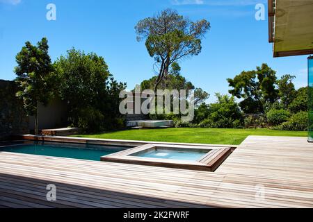 Vie moderne. Un jardin arrière contemporain avec piscine. Banque D'Images