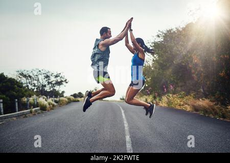 Nous l'avons fait et nous l'avons fait ensemble. Photo d'un jeune couple attrayant pour un marathon en plein air. Banque D'Images