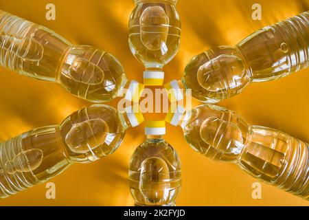 Vue de dessus des bouteilles en plastique avec huile de tournesol raffinée naturelle sur fond de couleur orange Banque D'Images