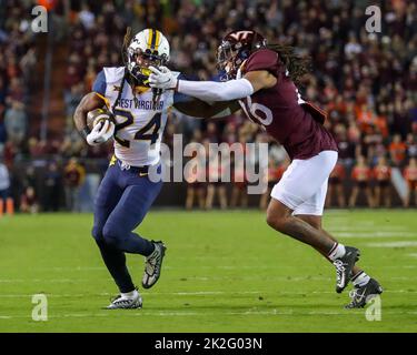 22 septembre 2022 : les alpinistes de Virginie occidentale qui ont fait la course de retour Tony Mathis Jr. (24) porte le ballon et a son masque saisi par Virginia Tech Hokies défensive dos Jalen Stroman (26) pendant le match de football NCAA entre les alpinistes de Virginie occidentale et les Hokies de Virginia Tech au stade Lane à Blacksburg, en Virginie. Greg Atkins/CSM Banque D'Images