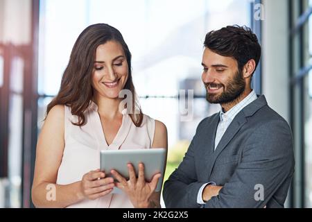 Les cadres intelligents utilisent une technologie intelligente. Photo d'un jeune homme d'affaires et d'une femme d'affaires utilisant une tablette numérique ensemble dans un bureau. Banque D'Images