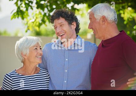 Ils ne pouvaient pas être plus fiers. Photo courte d'un couple senior debout à l'extérieur avec son fils. Banque D'Images