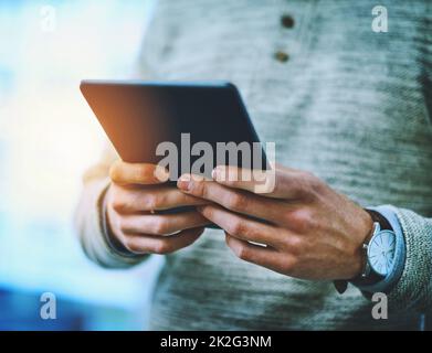 HES utilise toujours Internet à son avantage. Photo d'un homme d'affaires méconnu utilisant sa tablette numérique au travail. Banque D'Images