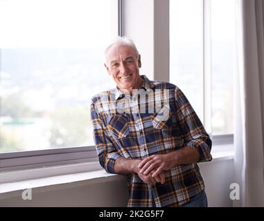 Au revoir tension, bonjour pension. Portrait d'un beau homme âgé debout devant une fenêtre par temps lumineux. Banque D'Images