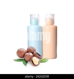 Bouteilles de cosmétiques naturels avec noix de macadamia sur fond blanc Banque D'Images