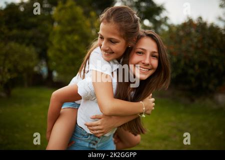 Je suis son plus grand supporter. Portrait court d'une jeune fille donnant à sa jeune sœur une promenade en plein air. Banque D'Images