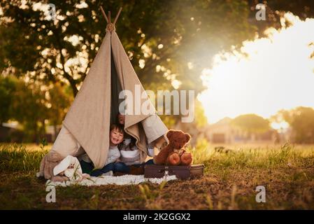 Arrêtez qui va là-bas. Portrait de deux jolis petits frères et sœurs jouant ensemble dans une tipi à l'extérieur. Banque D'Images