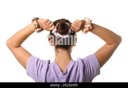 Woman with bun hairstyle and different silk scrunchies on white background Stock Photo