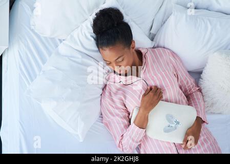 Shes ayant de beaux rêves. Photo en grand angle d'une jeune femme attrayante dormant paisiblement dans le lit à la maison. Banque D'Images