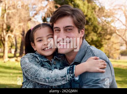 Ma petite fille fond mon cœur. Photo d'une adorable petite fille embrassant son père au parc. Banque D'Images