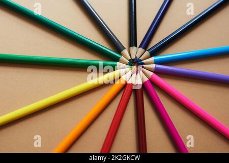 La vie est bien plus que le noir et blanc. Prise de vue en studio de crayons de différentes couleurs sur fond marron. Banque D'Images