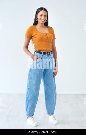 Pour un look décontracté. Portrait d'une jeune femme attrayante debout avec sa main dans sa poche en studio. Banque D'Images