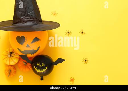 Composition with Halloween balloons and pumpkins on color background Stock Photo