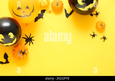 Composition with Halloween decor and pumpkins on yellow background Stock Photo