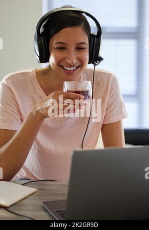 Aujourd'hui est un grand jour pour quelques connaissances nouvelles. Photo d'une jeune femme qui boit du thé tout en travaillant à domicile. Banque D'Images