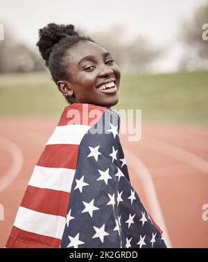 Vous êtes à la recherche d'une étoile. Prise de vue d'une jeune athlète féminine avec le drapeau américain enveloppé autour d'elle. Banque D'Images