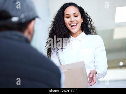 J'ai hâte de l'ouvrir. Photo d'une jeune femme qui reçoit sa livraison du service de messagerie. Banque D'Images