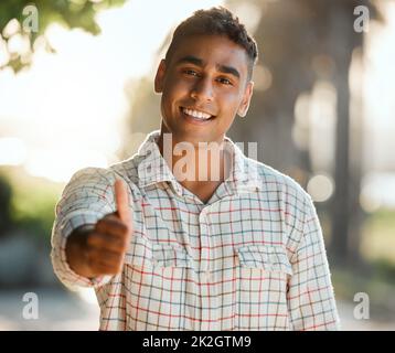 Prêt à cueillir beaucoup plus de petits pains brillants. Photo d'un jeune homme qui donne un pouce sur une ferme. Banque D'Images