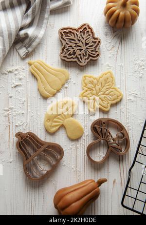 Cuisson de biscuits sous forme de citrouille et de feuilles. Pâtisserie d'automne confortable. Pâte avec emporte-pièces. Banque D'Images