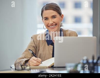 Je vous ai réservé, ne vous inquiétez pas. Photo d'une jeune femme d'affaires attirante assise seule dans son bureau et écrivant des notes. Banque D'Images