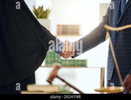 Combattons ensemble l'injustice. Photo de deux avocats méconnaissables qui se sont secoués la main au travail. Banque D'Images