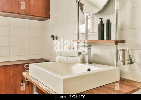 Glass partition between shower tap and wall flush toilet in barhroom at home Stock Photo