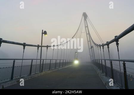 Pont suspendu à Herrenkrug près de Magdeburg sur la piste cyclable d'Elbe avec lumière d'un cycliste dans le brouillard Banque D'Images