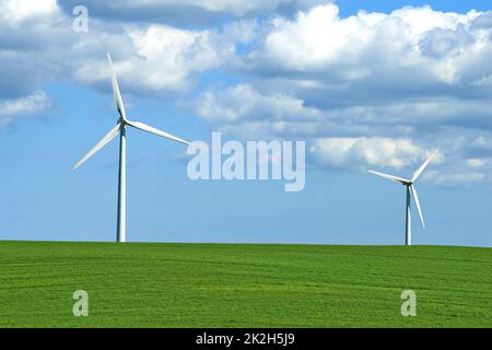 Creating energy with the wind. wind turbines on a grassy field. Stock Photo