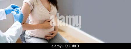 Médecin effectuant l'injection du vaccin Covid-19 à la femme enceinte Banque D'Images