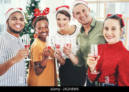 Nous souhaitons à tout le monde une joie et Joyeux Noël. Portrait d'un groupe d'hommes d'affaires créatifs qui boivent du champagne et fêtent ensemble à leur bureau la fête de Noël. Banque D'Images