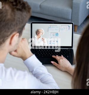 Business webinar. Video presentation. Distance education. Students watching senior female coach online marketing lesson on laptop screen at home. Stock Photo