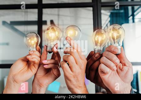 Travail d'équipe et remue-méninges avec des hommes d'affaires qui partagent une idée avec une lampe Banque D'Images