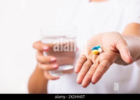 Femme tenir les médicaments de pilule dans la main prêt prendre des médicaments avec un verre d'eau Banque D'Images