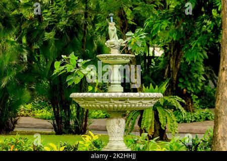 La vieille fontaine blanche dans le parc est un dispositif populaire pour la décoration de jardin Banque D'Images