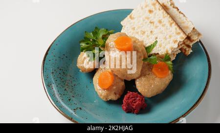 Poisson Gefilte avec carotte. Assiette de poisson gefilte traditionnel de Pessah sur table Banque D'Images