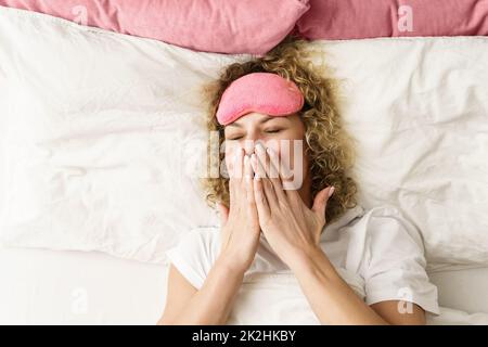 Belle femme aux cheveux bouclés se réveillant après un bon sommeil Banque D'Images