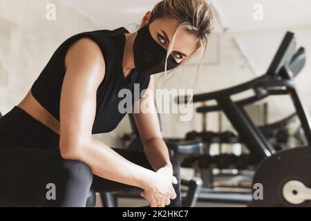 Jeune femme sportive portant un masque de prévention pendant son entraînement physique. Banque D'Images