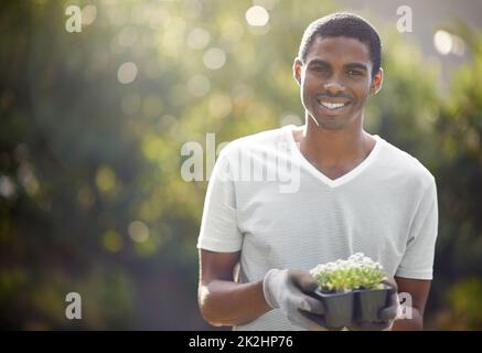 Planting for the future. Portrait of a handsome young man gardening. Banque D'Images