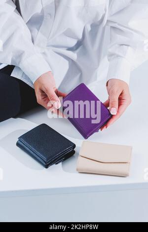 A stylish woman holds a purple leather purse in her hands. Small women's handbag Banque D'Images